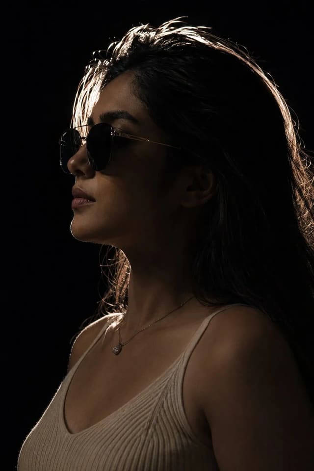 Dark silhouette fashion portrait with dramatic rim lighting