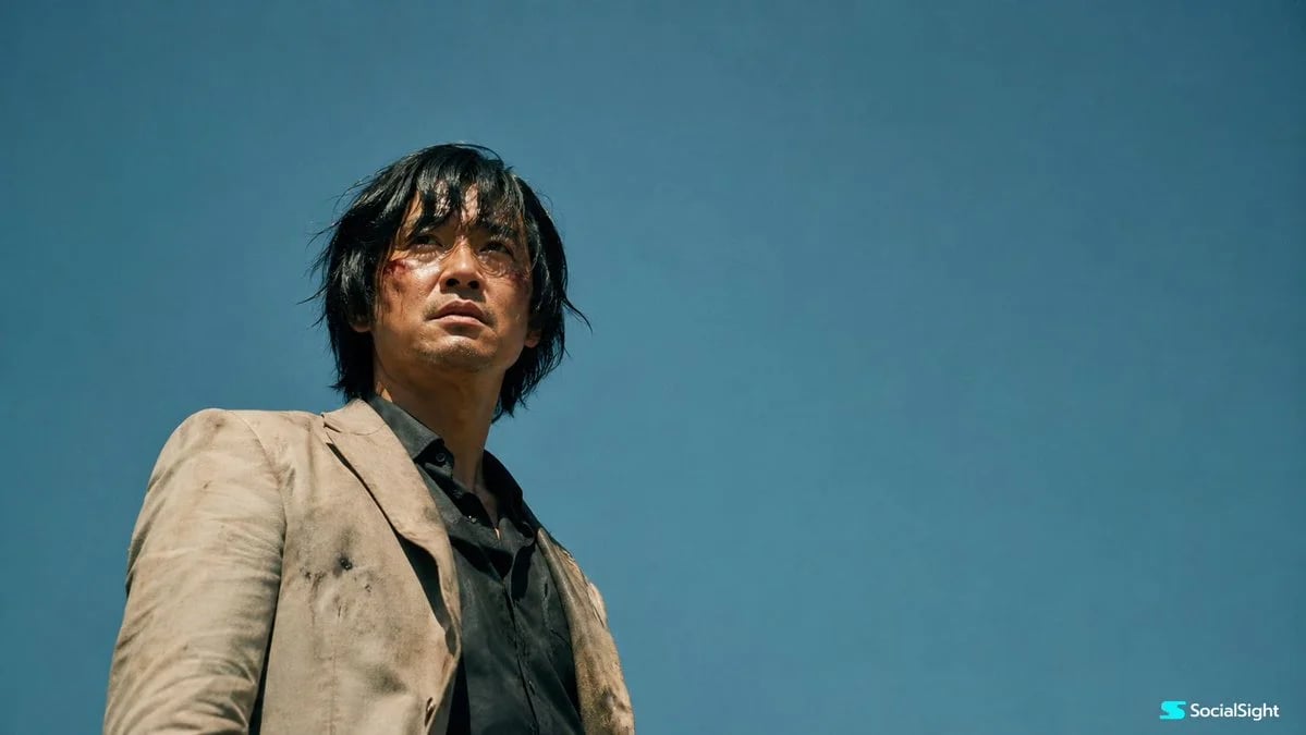 Cinematic low-angle film still of a wounded man under a vast blue sky